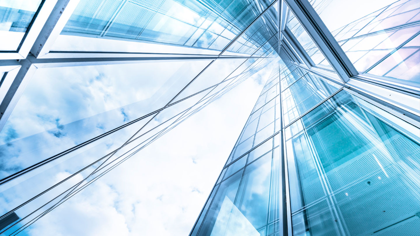 ???  Looking up at a tall glass building toward blue sky